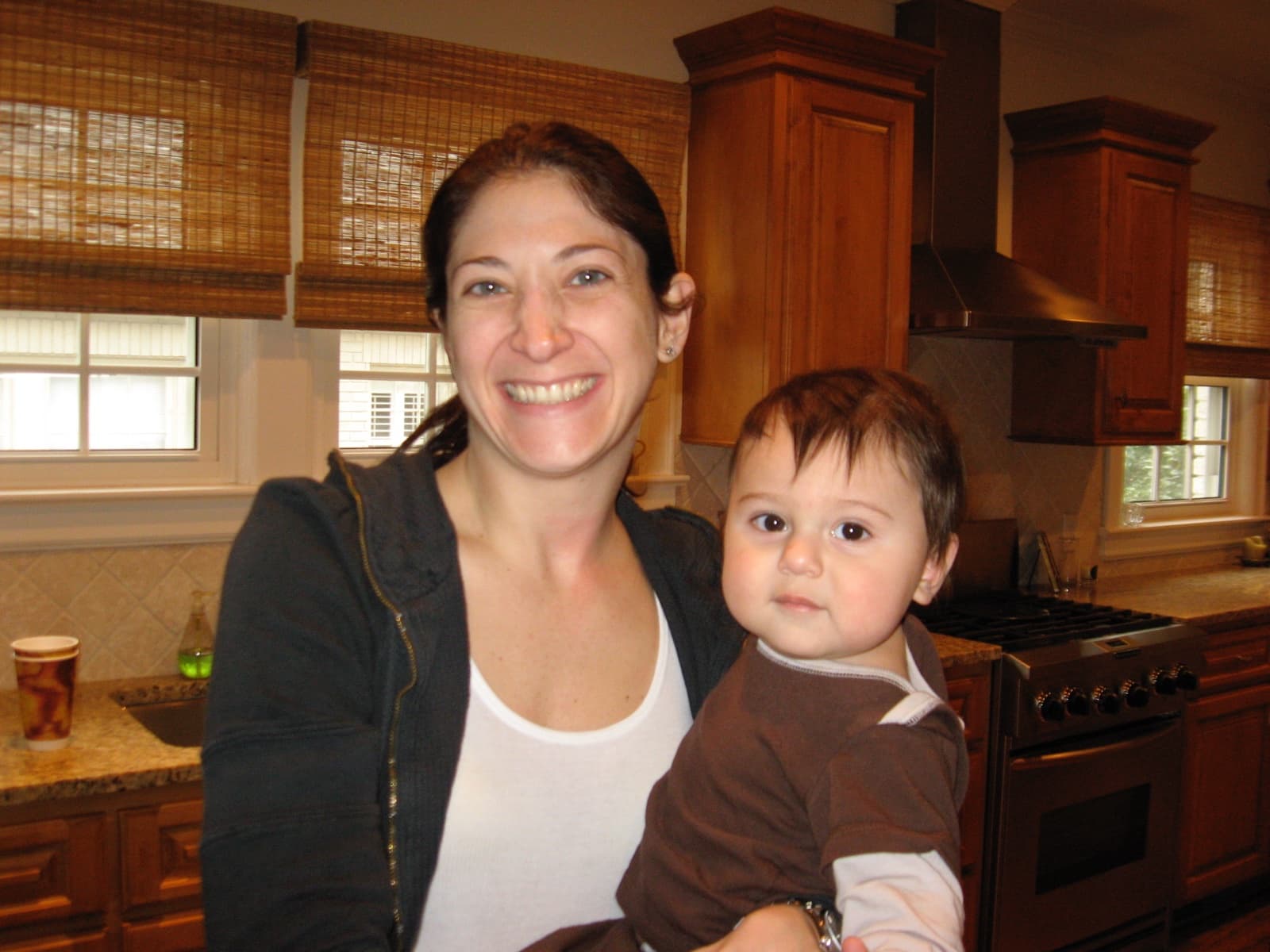 Mom in the kitchen, holding baby Mack - the room where a thousand Sunday ragus happened.