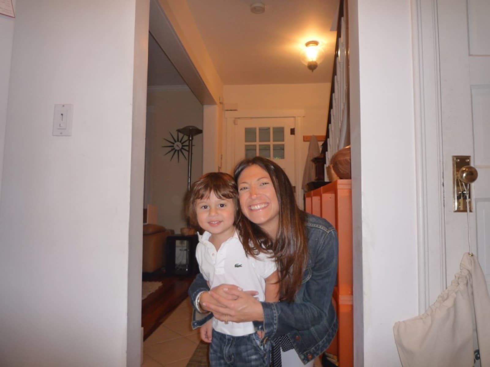 Mom holding toddler Mack in the hallway at home.